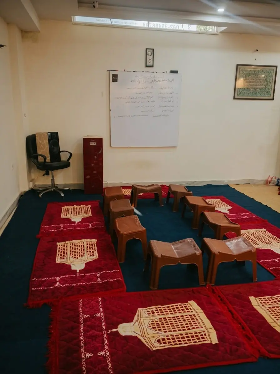 Classroom with prayer mats and Quran stands